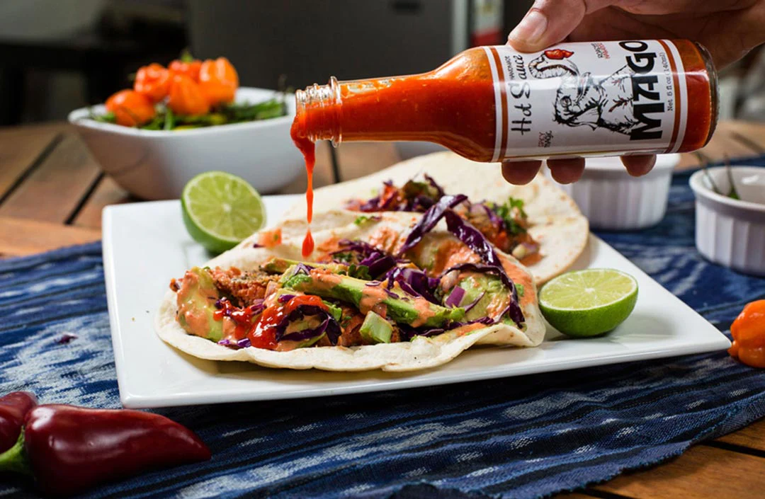 Mago Hot Sauce on a table with food